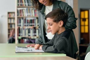 child and teacher reading at school