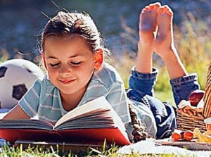 child reading outside during the summertime