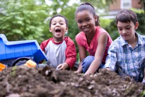 Two boys and one girl visibly happy playing along