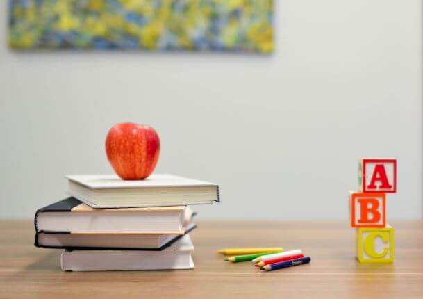 books, apple, and ABC cube on teachers table