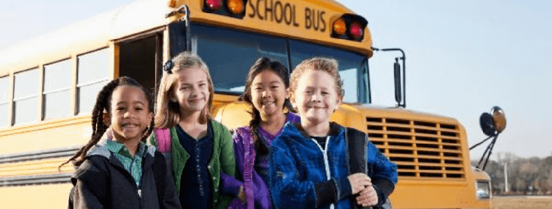 children in front of a school bus